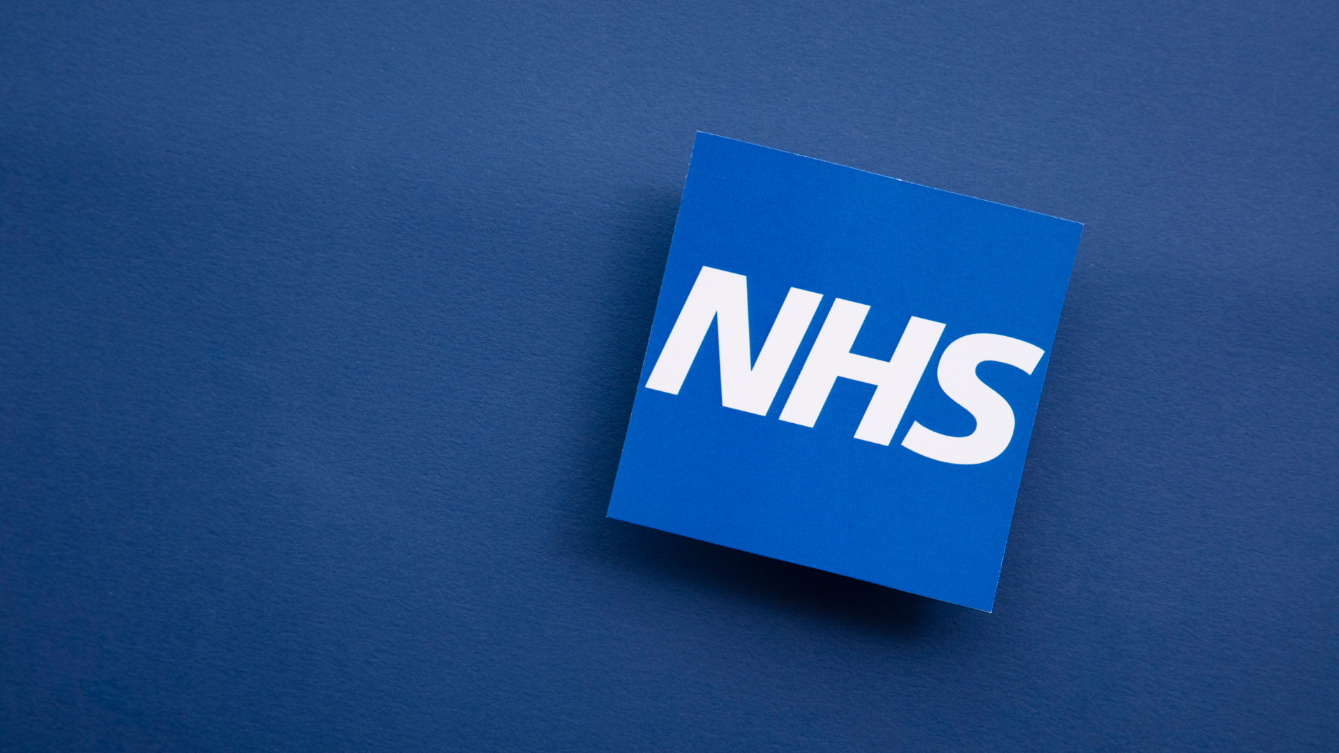 NHS logo on blue background.
