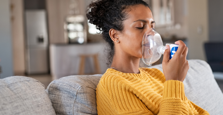 A woman using a nebuliser at home.
