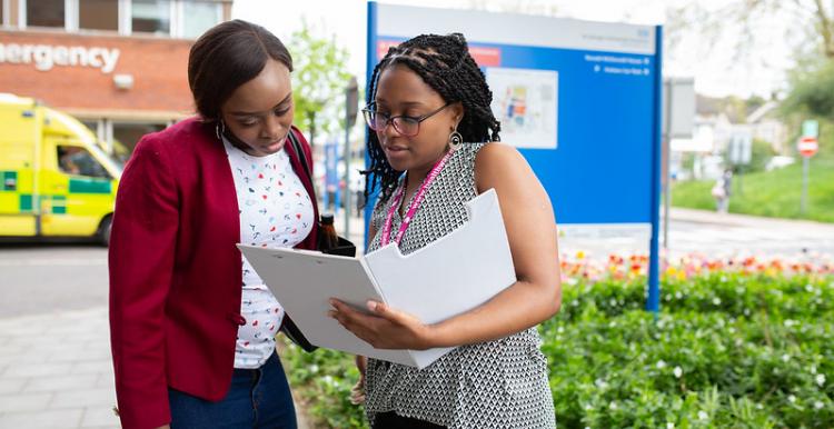 Two women stood talking outside a hospital