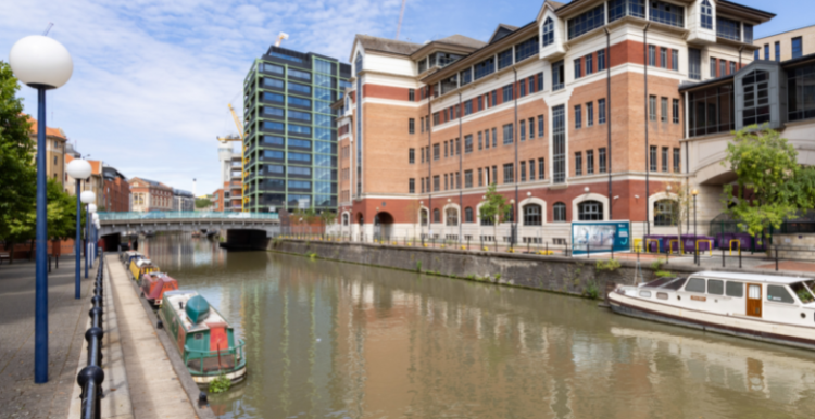 A large, modern brick building overlooking part of the Feeder Canal