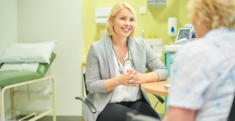 A doctor in their office, talking to a patient