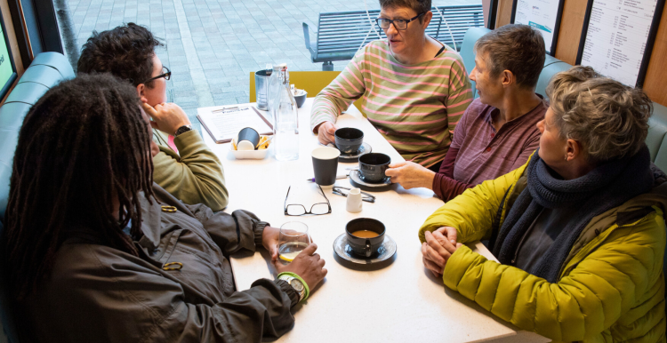 A group of women sitting around a table in a cafe