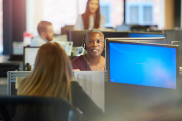 People using headsets and looking at computer screens in a call centre