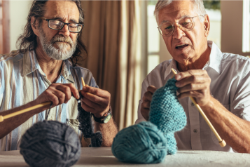 Two men knitting.