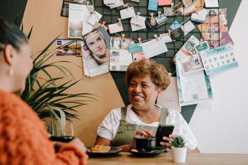 A woman chatting to a friend in a cafe.