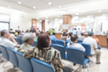 Blur medical background clinic service counter lobby with patient paying bill at cashier desk in hospital.