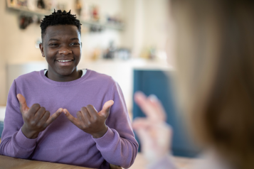 Teenage Boy And Girl Having Conversation Using Sign Language