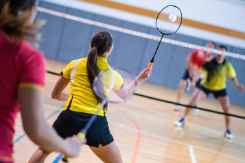 A group of women playing badminton.
