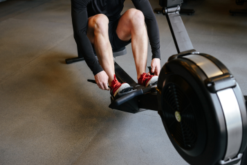 A person using a rowing machine in a gym.