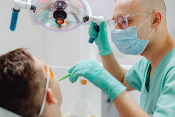 A dentist performing dental surgery on a patient.