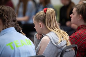 The backs of three young people sitting down