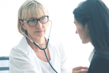 A doctor with a stethoscope listening to a patient's chest