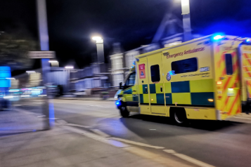 An ambulance racing down a residential street