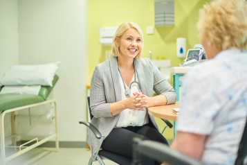 A doctor in their office, talking to a patient