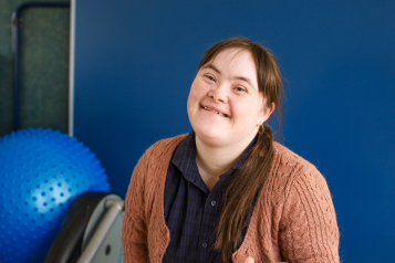 A young woman with a learning disability smiling