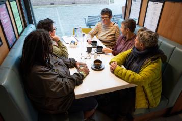 A group of women sitting around a table in a cafe