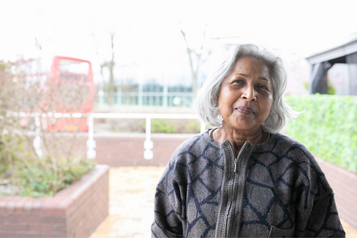 An older woman standing outside, smiling An older woman standing outside, smiling