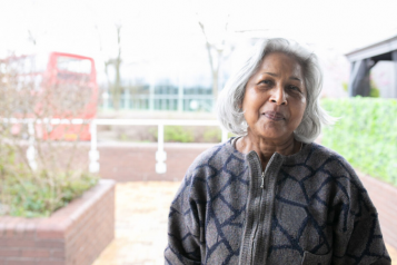 A woman in front of a plain background