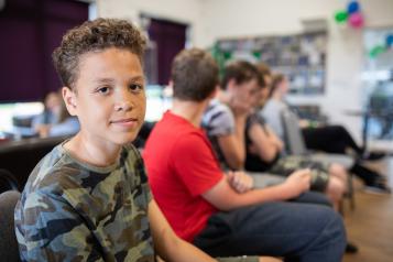 Teenage boy sat with his friends