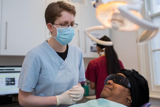 A dentist performing dental treatment on a woman