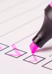 A pink highlighter being used to tick boxes on a list